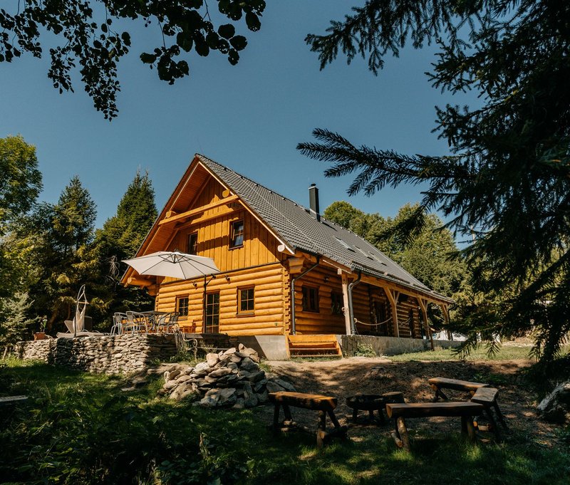 Chata u Lubátka - dřevěná roubenka s modrou střechou v zelené přírodě Jeseníků