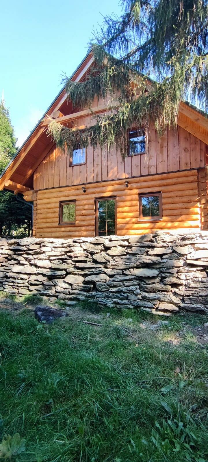 Chata u Lubátka - dřevěná roubenka s kamenným základem a modrou střechou